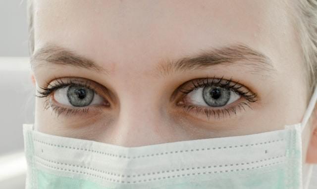 Close image of woman's eyes. She is wearing a medical face mask