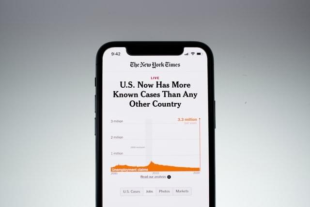 image of a cell phone displaying New York Times article with the headline U.S. Now Has More Known Cases Than Any Other Country